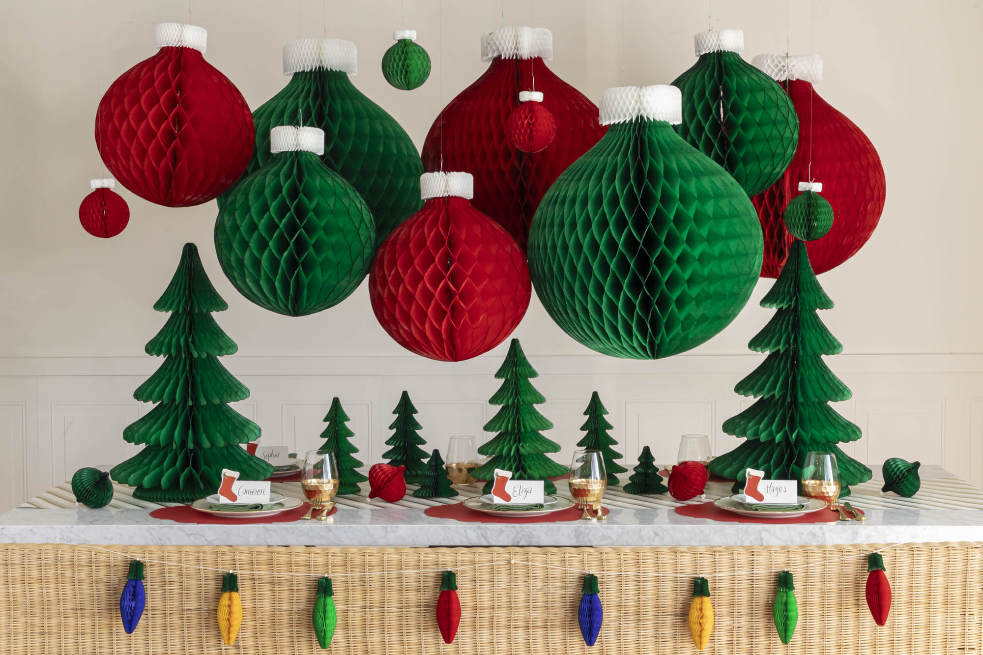 A Christmas table setting with Christmas Honeycomb Paper hanging from the ceilings and scattered across the table.