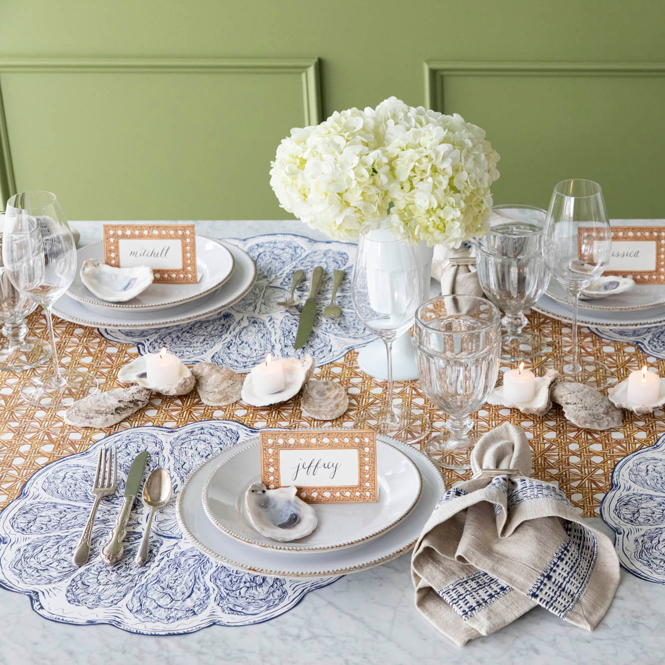 A seaside themed table setting featuring the Die-cut Blue Oyster Plate on the Rattan Weave Runner.