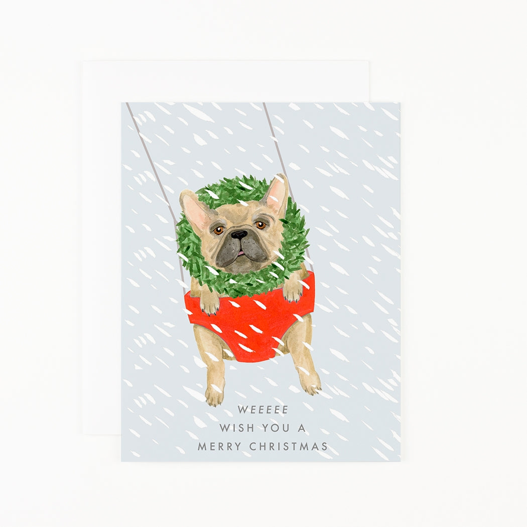 A hand painted frenchie wearing a wreath in a swing with snow text reads &quot;Weeeee Wish You a Merry Christmas&quot;