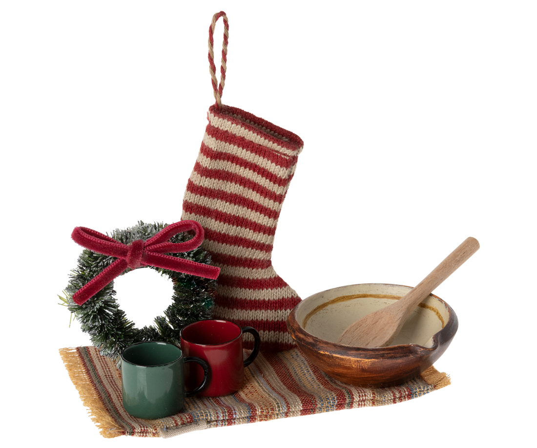 small stocking, rug, wreath, two cups and a bowl with a wooden spoon