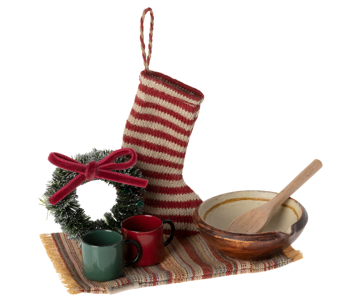 small stocking, rug, wreath, two cups and a bowl with a wooden spoon