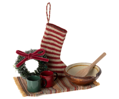 small stocking, rug, wreath, two cups and a bowl with a wooden spoon