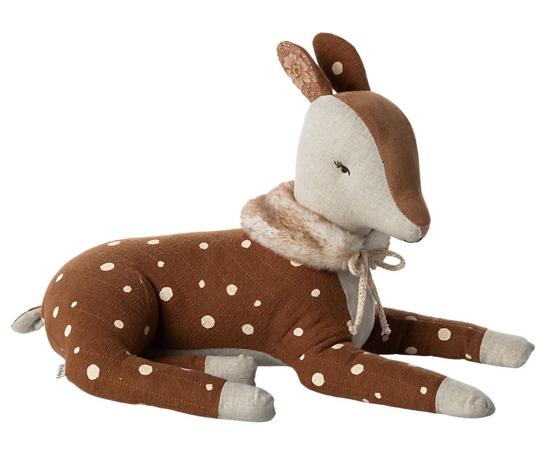 Stuffed animal brown deer with white spots and a faux fur scarf tied with a off white bow