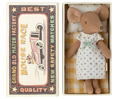 A vintage style Big Sister Mouse in Matchbox bed featuring a graphic of a Maileg mouse race car with text, next to a cotton linen toy mouse in a dress resting in an open matchbox.
