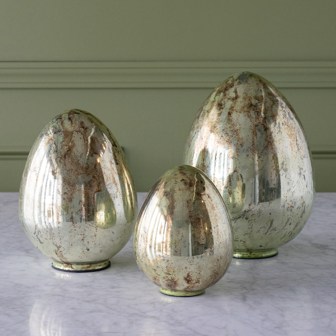 Mercury Glass Easter Eggs in three sizes on a table.