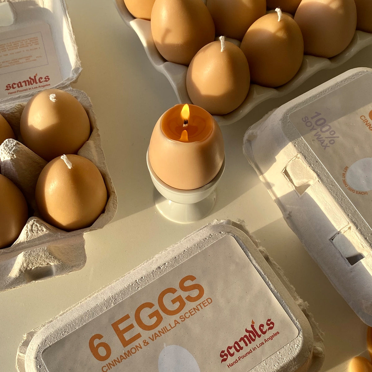 Overview of the egg candle burning surrounded by open and closed egg candle cartons. 