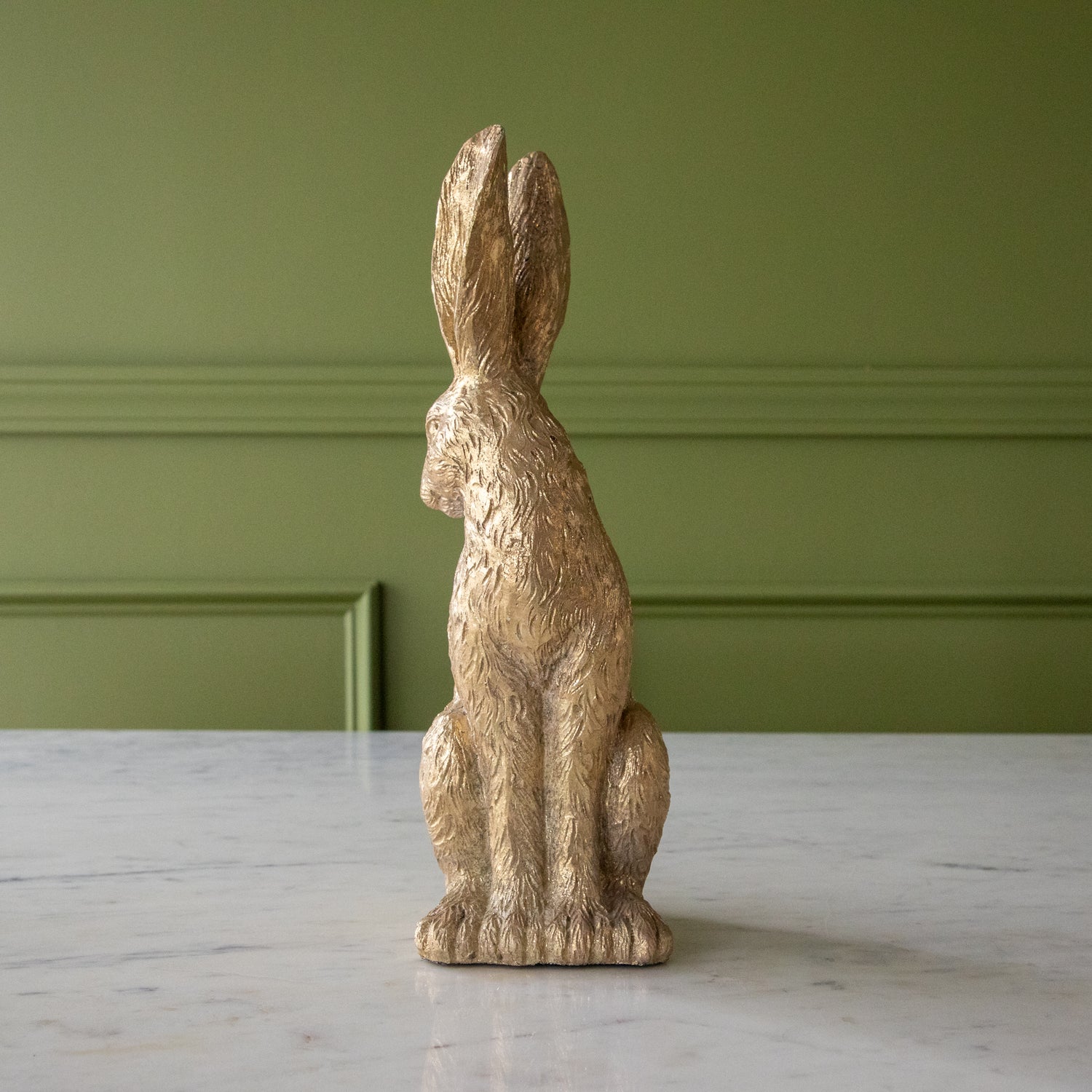 The front of the Head Down Gold Leaf Rabbit looking over its shoulder.