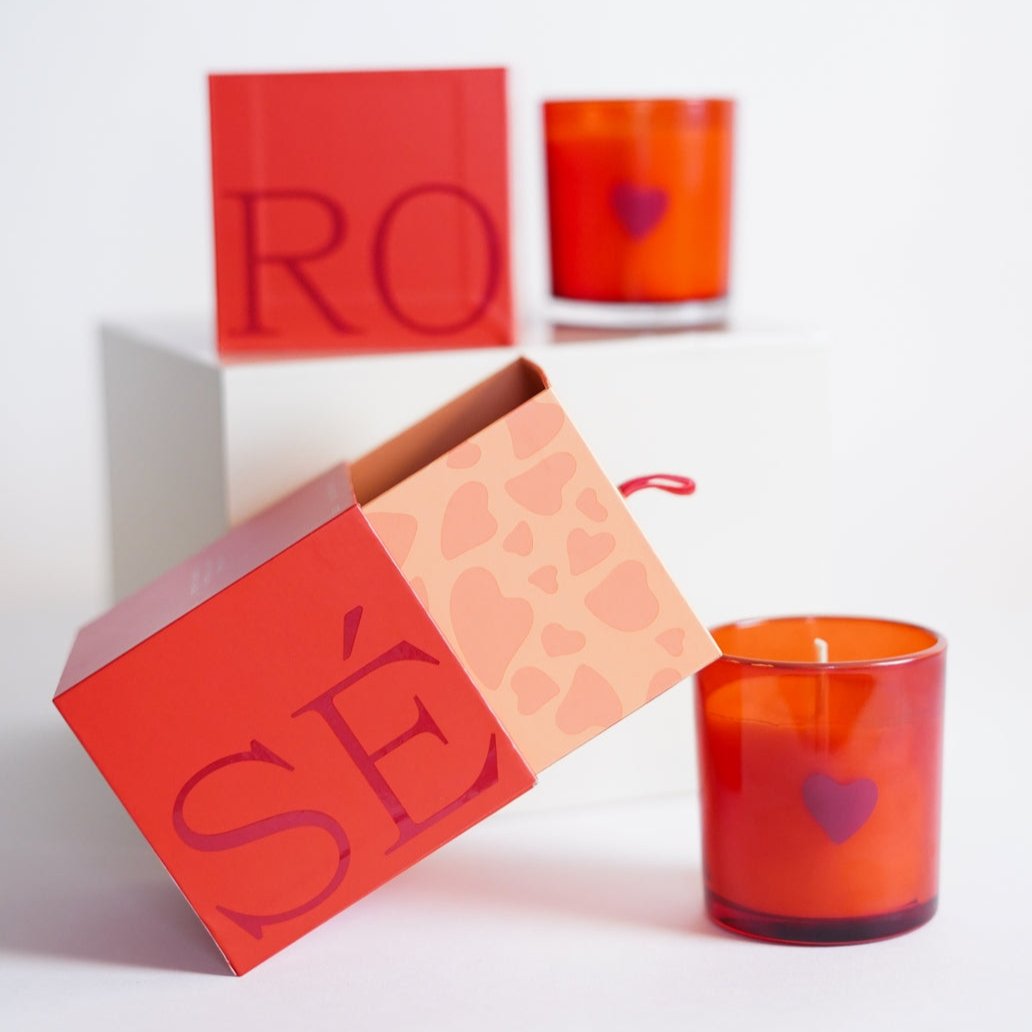 Rosé candle and its box.  The candle is red with maroon colored heart on it.  The box says ROSÉ. 