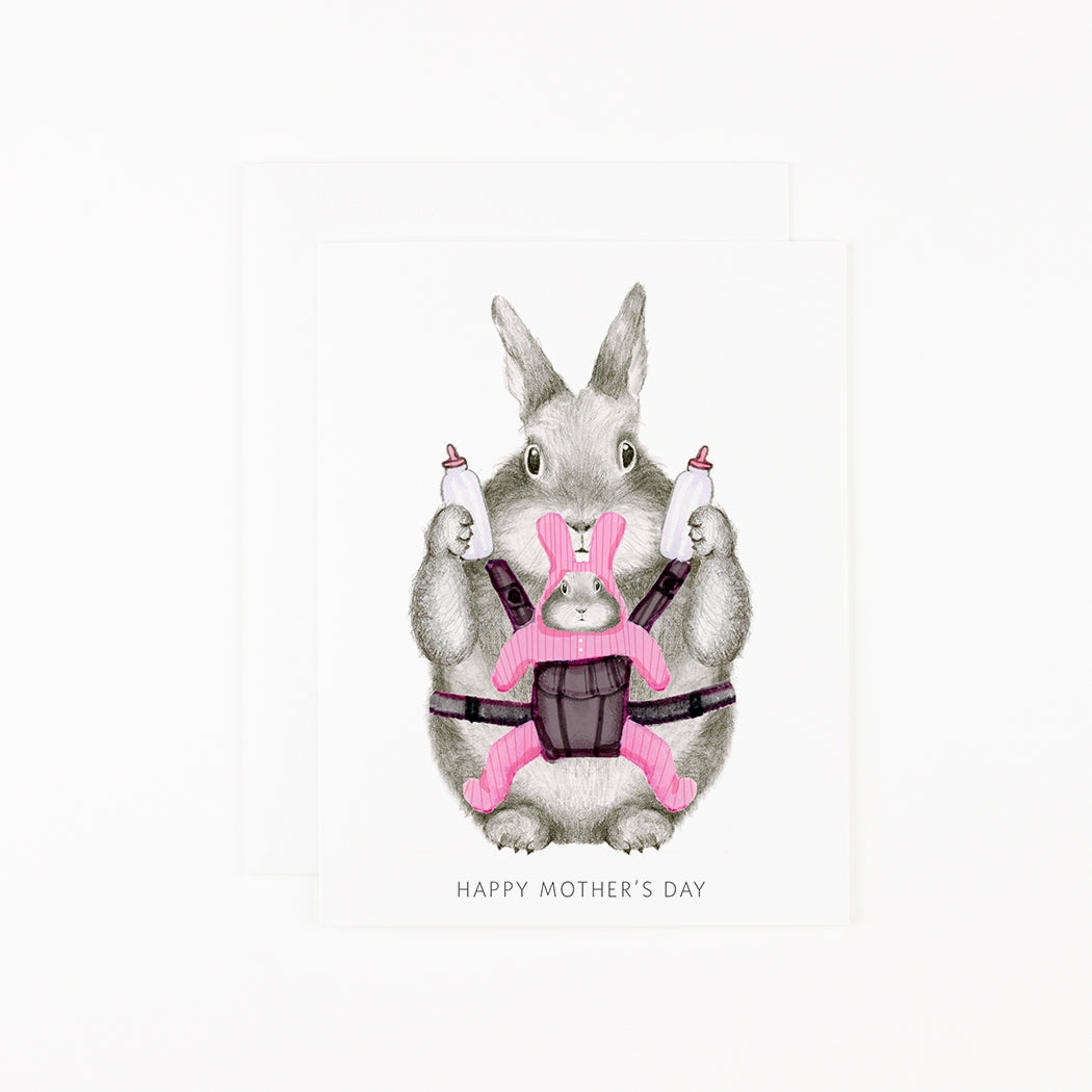 A hand drawn mom bunny holds a baby bunny in a baby bjorn with text that reads &quot;Happy mother&