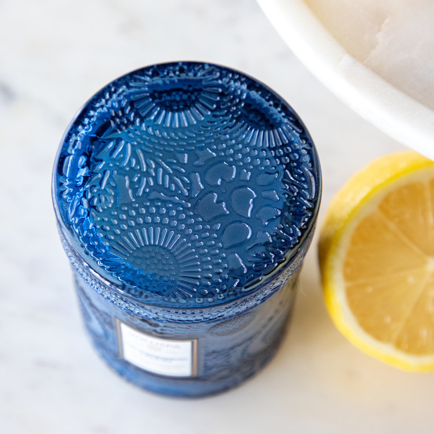 A close up of the lid of the small Mediterranean Lemon Candle showing its design in the glass.