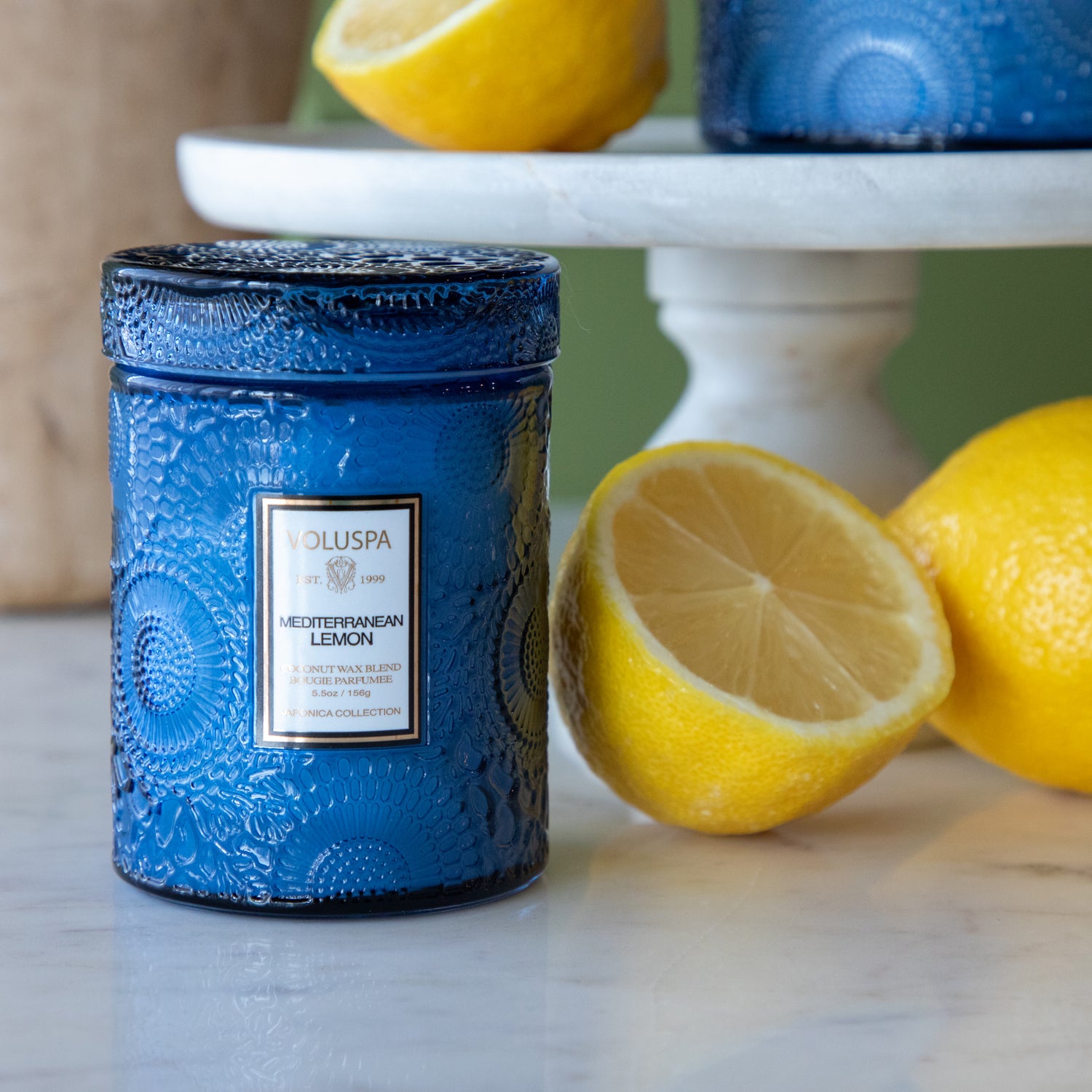 Small Mediterranean Lemon Candle next to lemons.