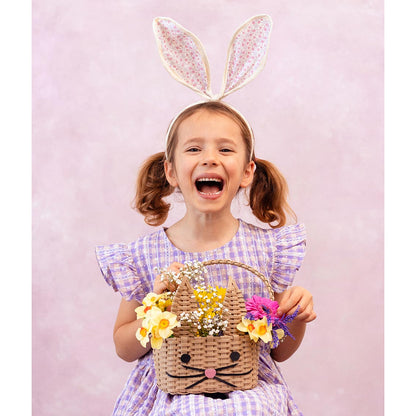 An excited child holding the Recycled Paper Bunny Shaped Basket with flowers in it.