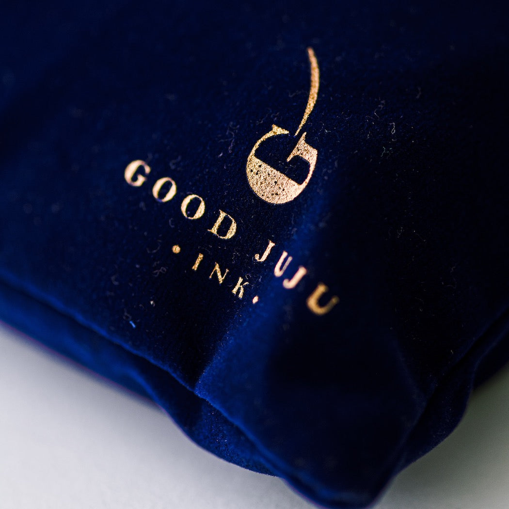 close up of gold good juju printed on the blue velvet bag the puzzle comes in