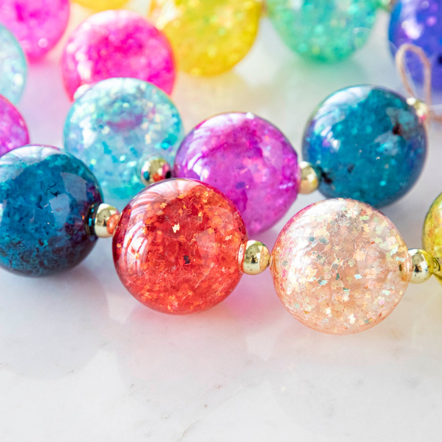 A colorful iridescent ball garland on a marble table.