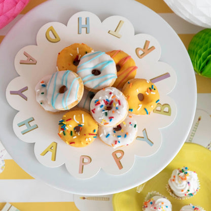 A plate of treats on a Happy Birthday Serving Paper from Hester &amp; Cook displayed on cake stands.