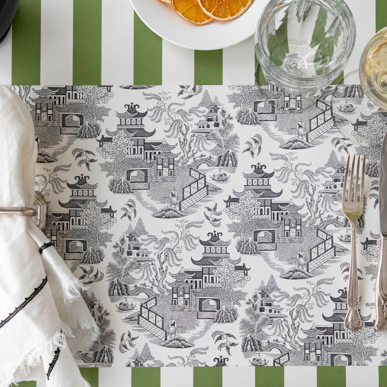 Black Willow Placemat on the Classic Moss Green Stripe Runner, and dinnerware on top.