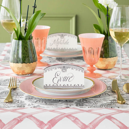 Black Willow Place Card with &quot;Evan&quot; written on it, resting on dinner plates on an elegant place setting.