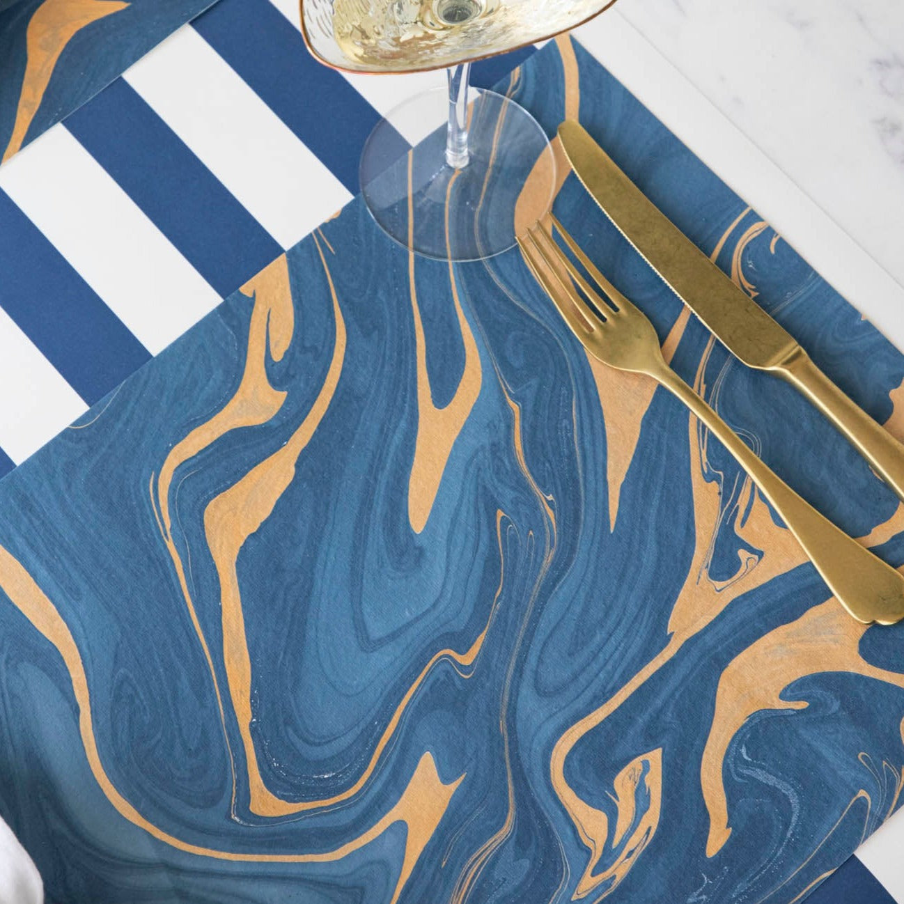 A close-up of the Blue &amp; Gold Vein Marbled Placemat under an elegant place setting.