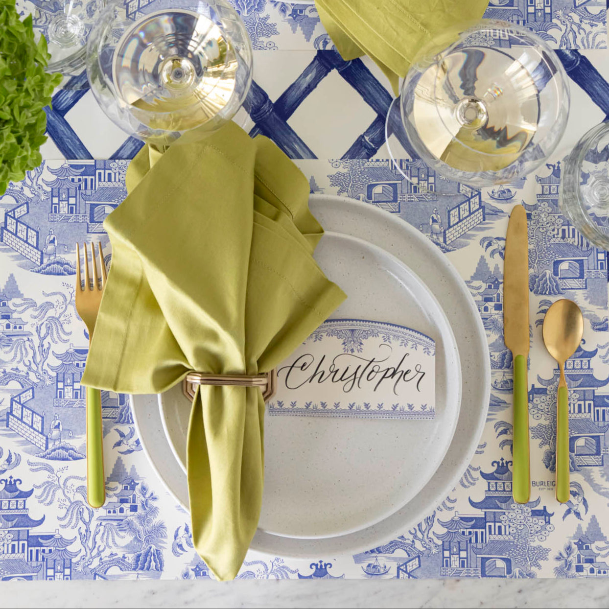 Blue Willow Classic Placemat with the Blue Lattice Runner underneath, styled with a place setting for one featuring colors of green and gold.