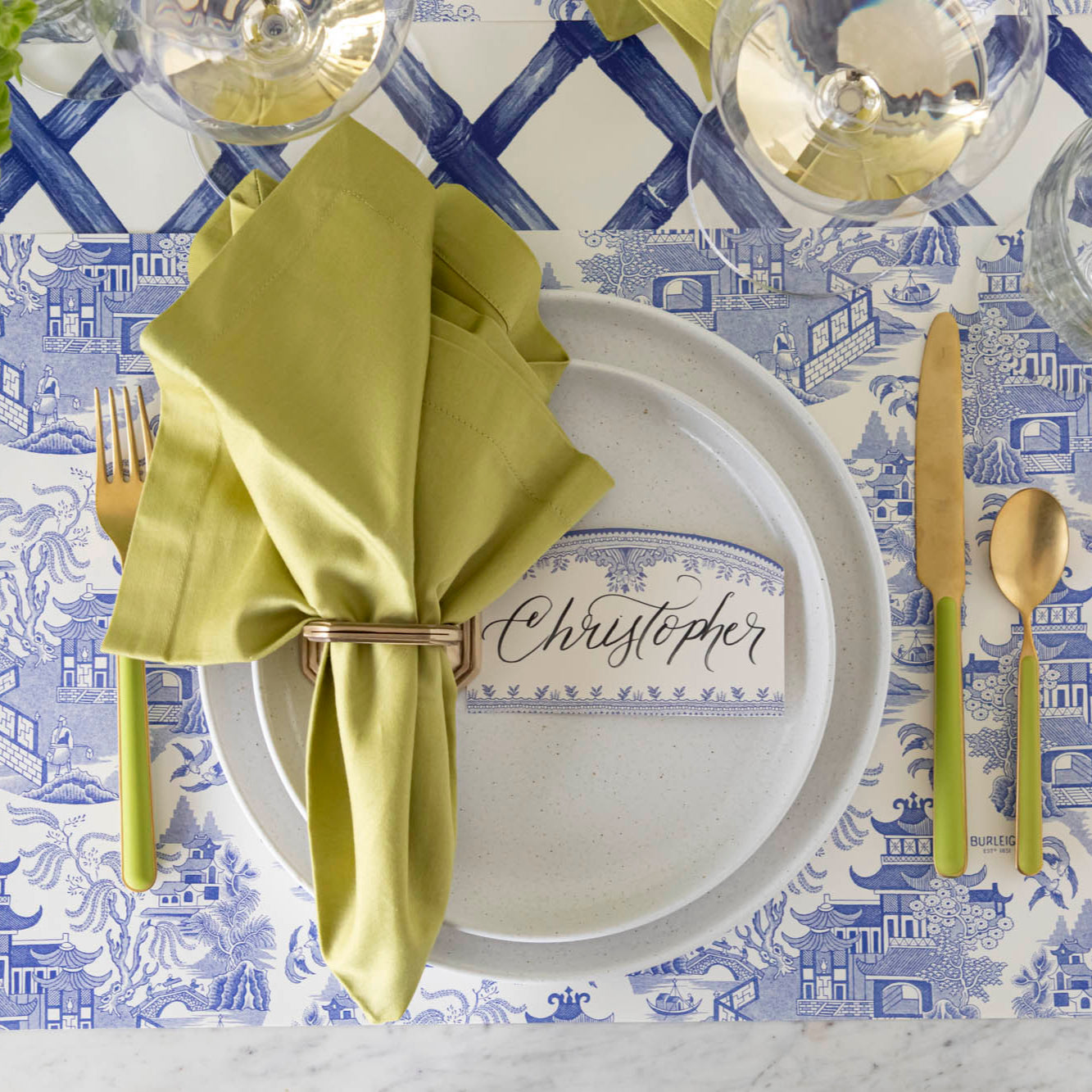 The Blue Willow Place Card with &quot;Christopher&quot; written in the white space, on an elegantly styled place setting for one.