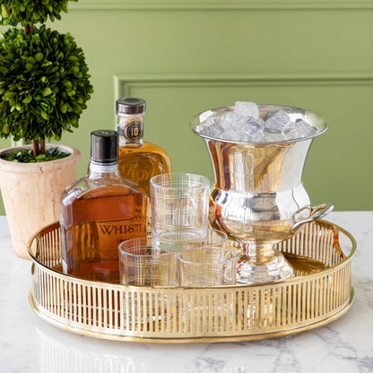 brass oval tray styled with various liquor bottles and barware