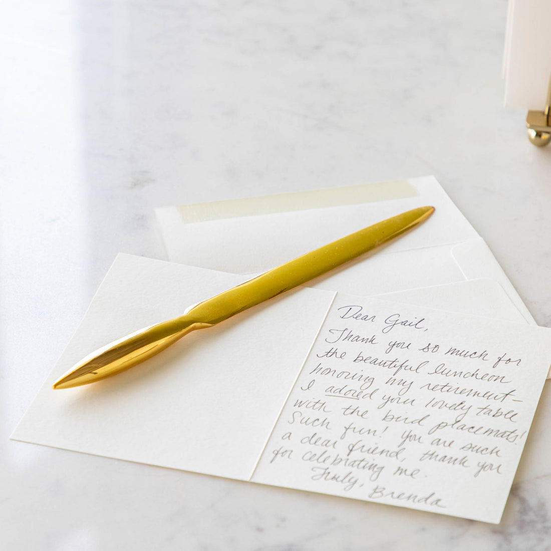 brass letter opener next to greeting card