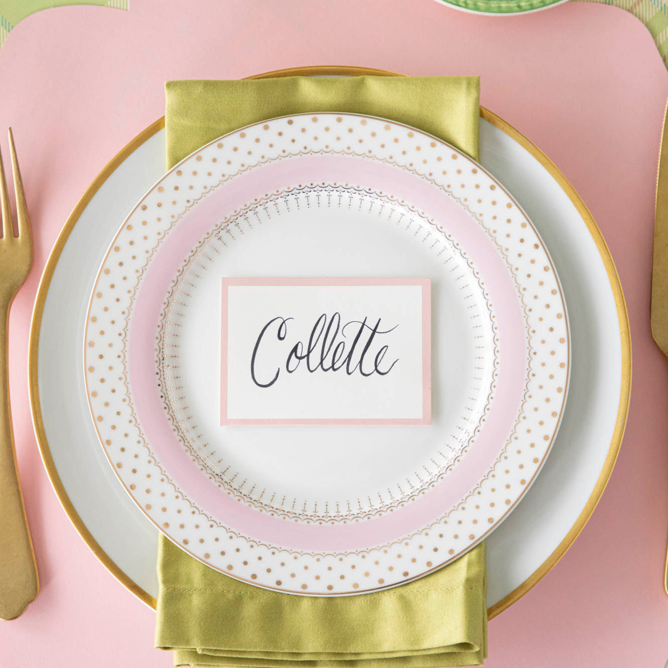 Pink Frame Place Card with &quot;Collette&quot; written in script, on a set of dinner plates on a colorful place setting.