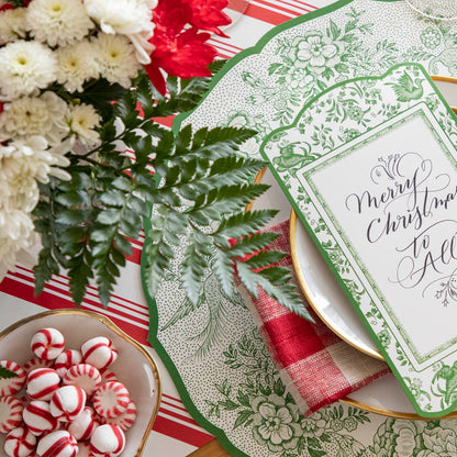 An elegant Christmas table setting featuring the Die-cut Green Asiatic Pheasants Placemat paired with the Green Asiatic Pheasants Table Card and florals and peppermints.