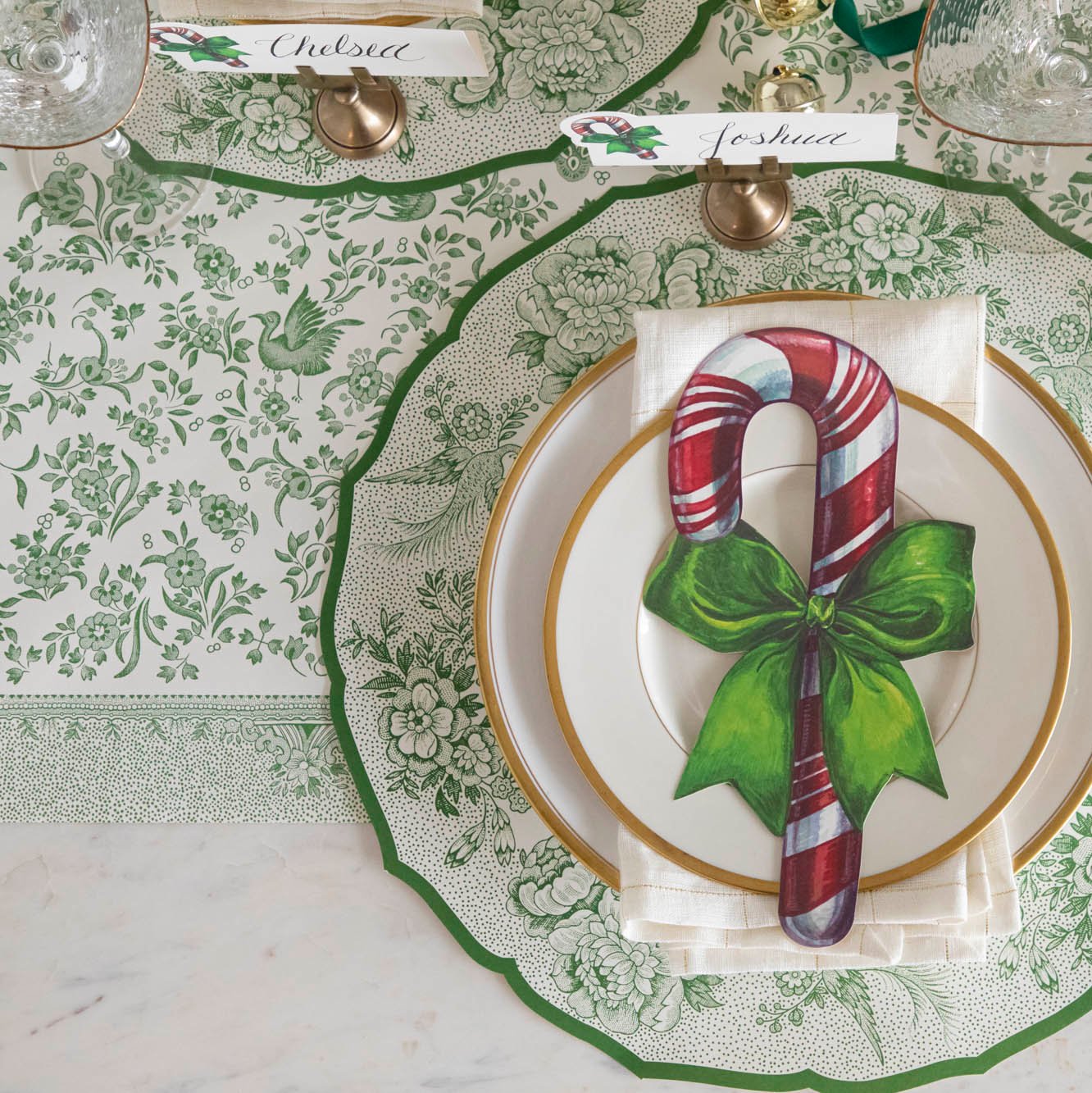 An elegant table setting featuring the Green Regal Peacock Runner paired with the Die-cut Green Asiatic Pheasants Placemat and Candy Cane Table Accent resting on plates.