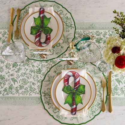 An elegant table setting featuring the Die-cut Green Asiatic Pheasants Placemat paired with the Candy Cane Table Accent and Green Regal Peacock Runner underneath.