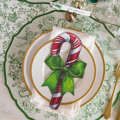 An elegant table setting featuring the Die-cut Green Asiatic Pheasants Placemat paired with the Candy Cane Table Accent and Green Regal Peacock Runner underneath.