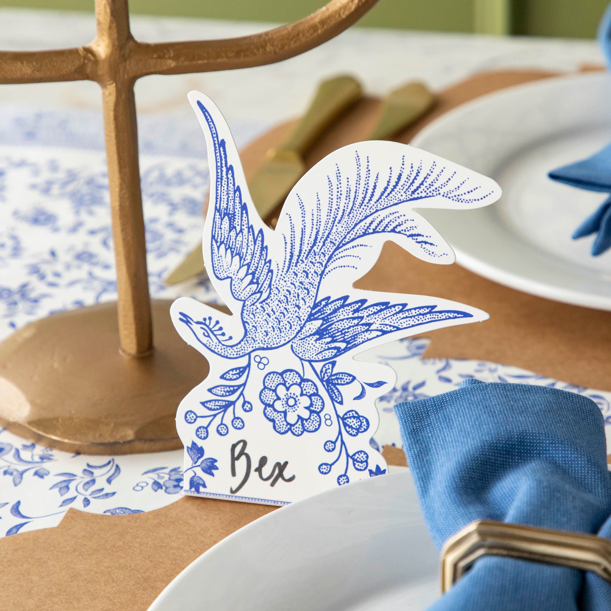 Blue Asiatic Pheasants Place Card with &quot;Bex&quot; written on it, behind an elegant place setting.