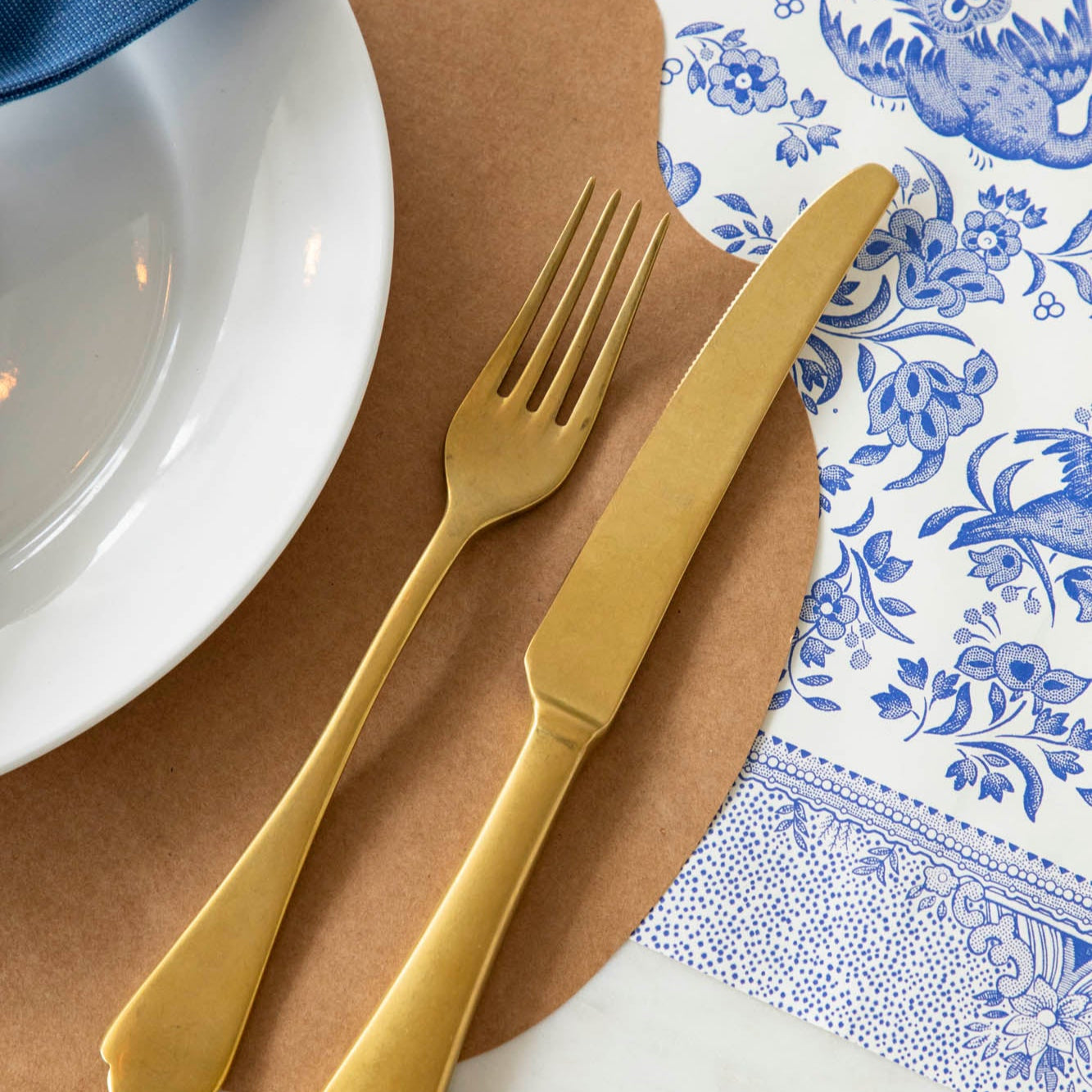 Blue Regal Peacock Runner under the Kraft French Frame Placemat with a place setting. 