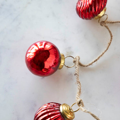 A close up of the Embossed Mercury Glass Ornament showing the round ornament and jute cord.