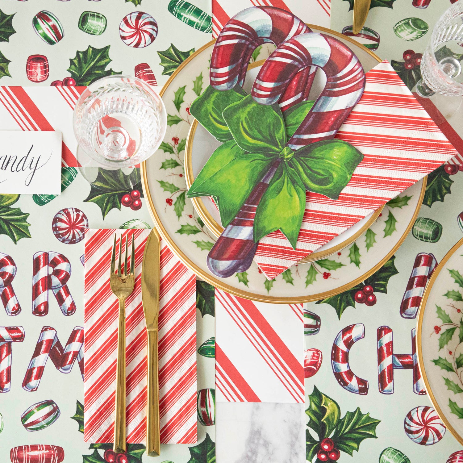 A candy cane themed table setting featuring the Candy Cane Table Accent on Holly Plates and Peppermint Stripe Napkins.