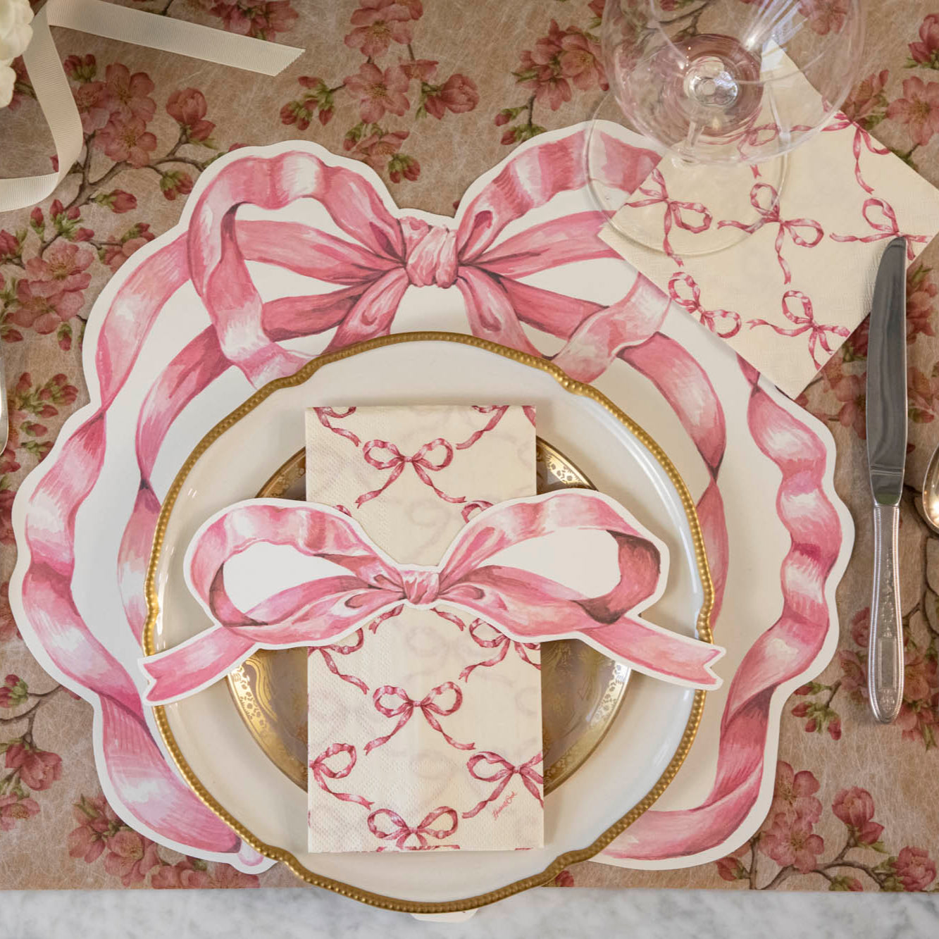 An elegant place setting with the Pink Bow Table Accent on the Pink Bow Guest Napkin, centered on the plates.