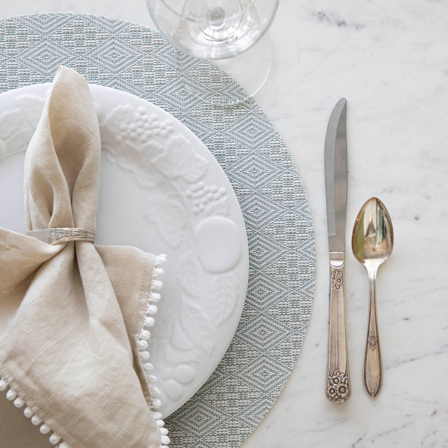 Boxwood Round Placemat with place setting on it