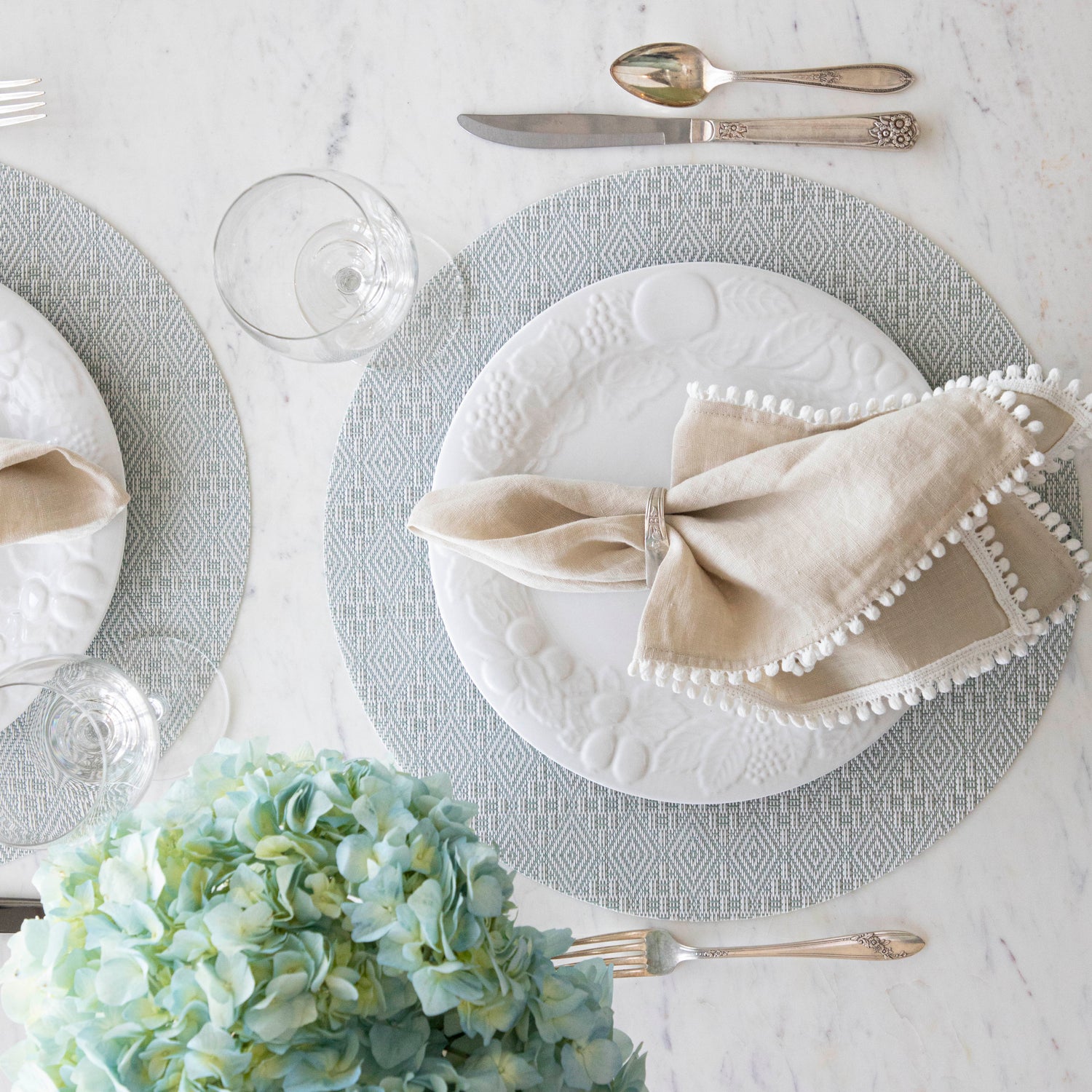 Boxwood Round Placemat with place setting on it