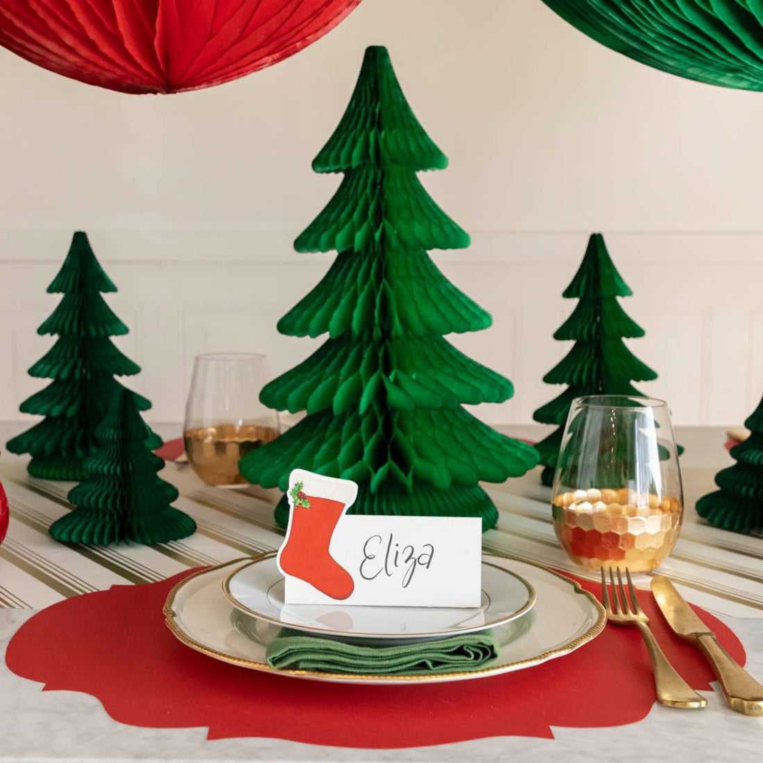 An elegant Christmas table setting with the Honeycomb Extra Large Tree behind a plate, next to smaller honeycomb trees.