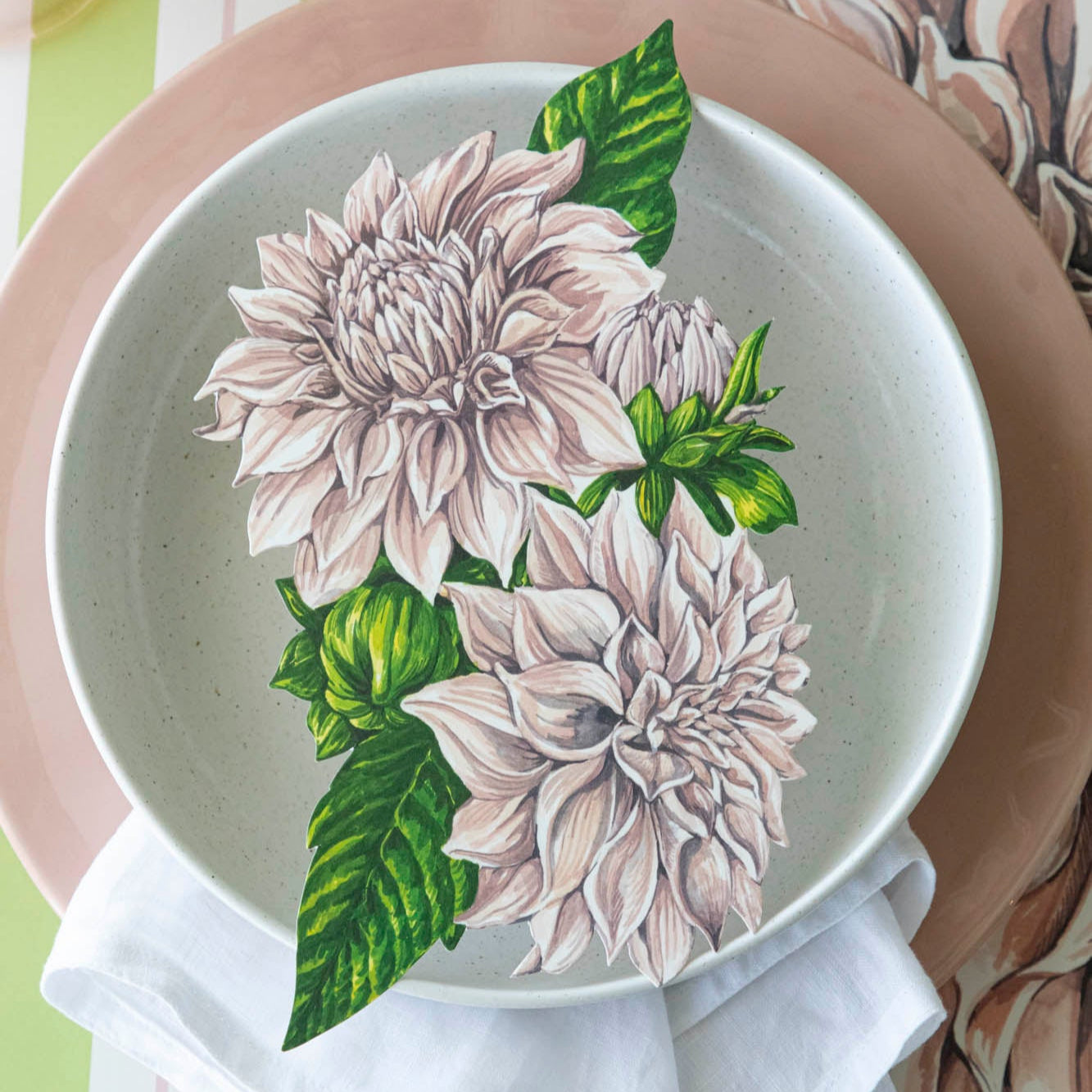 Dahlia Table Accent resting in the center of dinner plates on a place setting.