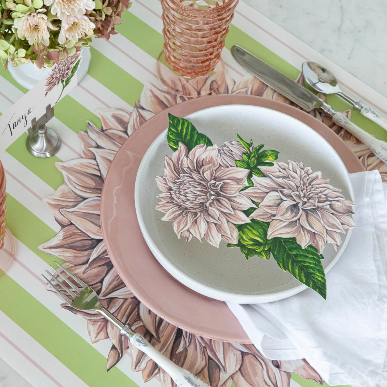 Die-cut Dahlia Placemat on the Green &amp; Pink Awning Stripe Runner, under a place setting for one.