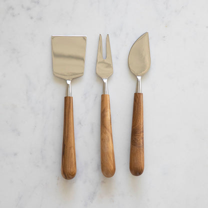 Teak &amp; Stainless Cheese Set by Be Home on a marble table.