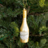 Congratulations Gold Champagne Ornament hanging on a tree.