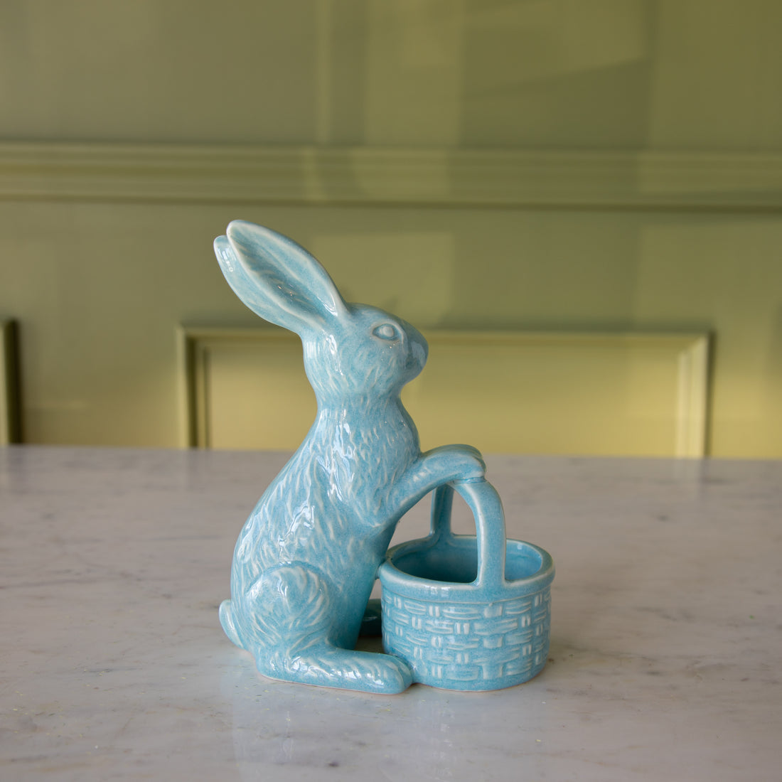 Side view of the Blue Ceramic Embossed Bunny Holding Basket.