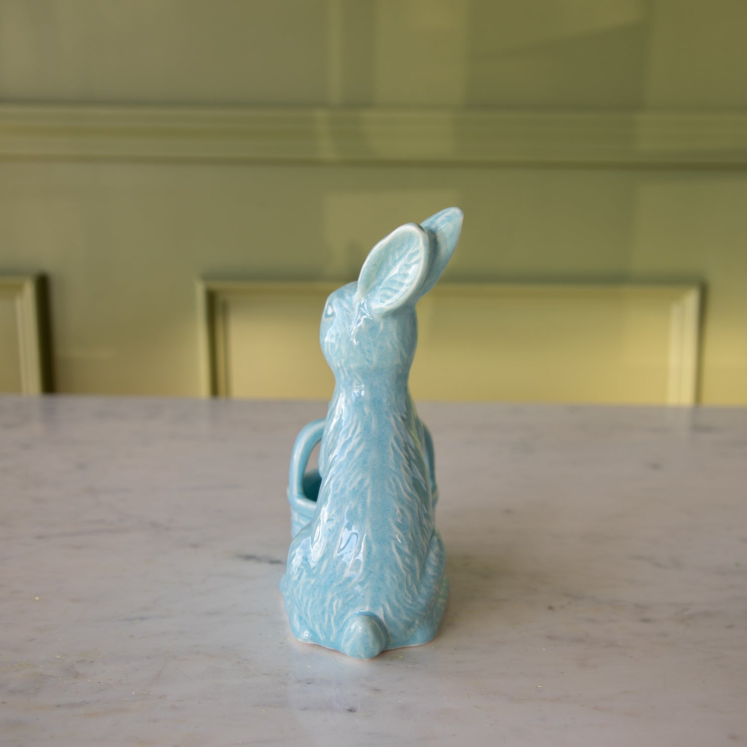 Back view of the Blue Ceramic Embossed Bunny Holding Basket showing embossed details of fur and its pom tail.