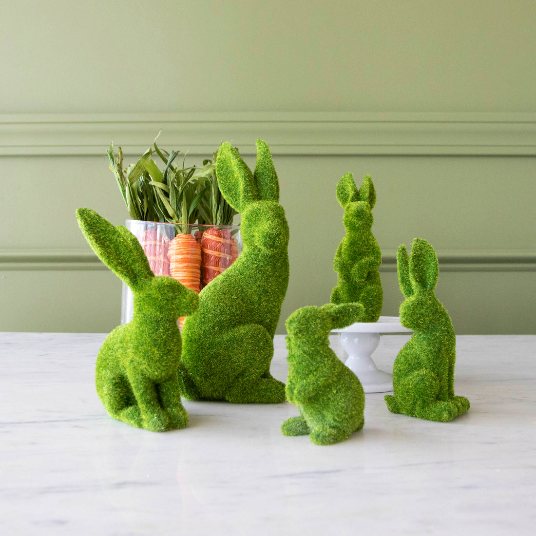 Green Flocked Bunnies ranging from extra small to extra large, in front of a jar of decorative carrots.