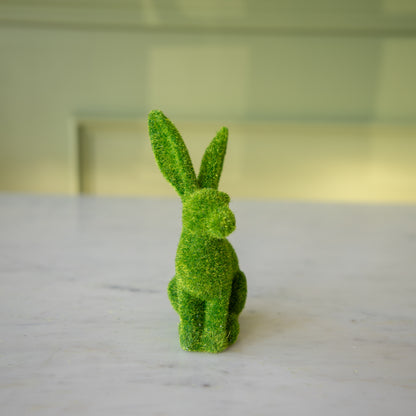 The front view of the large green flocked bunny perched up looking to the side.