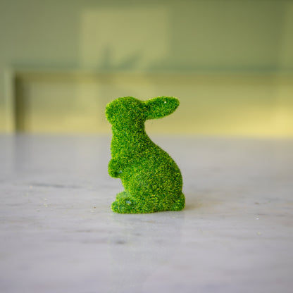 The side view of the extra small green flocked bunny on its hind legs and ears all the way back.