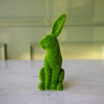 The front view of the extra large green flocked bunny sitting up, looking over its shoulder.