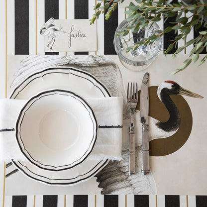 Crane Place Card with &quot;Justine&quot; written on it, behind an elegantly styled place setting for one.